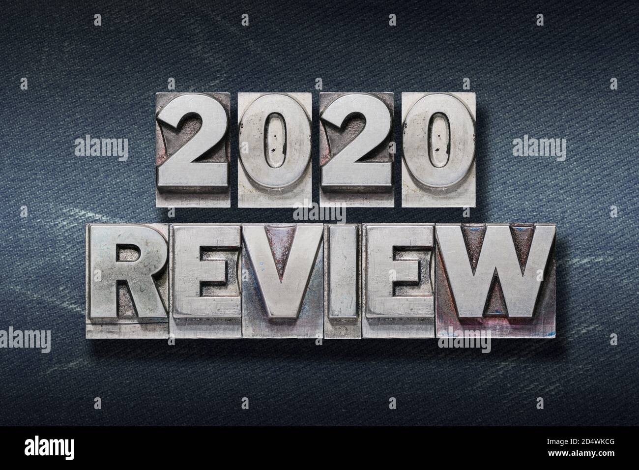review 2020 phrase made from metallic letterpress on dark jeans background Stock Photo