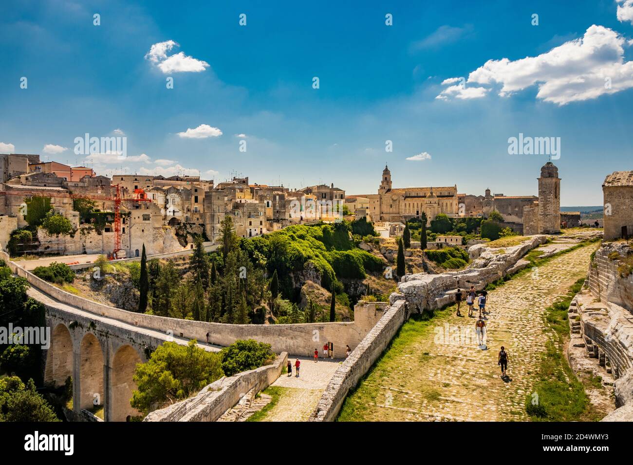 Gravina in Puglia, Italy. The stone bridge, ancient aqueduct and viaduct. Across the valley the skyline of the city with its houses and buildings and Stock Photo