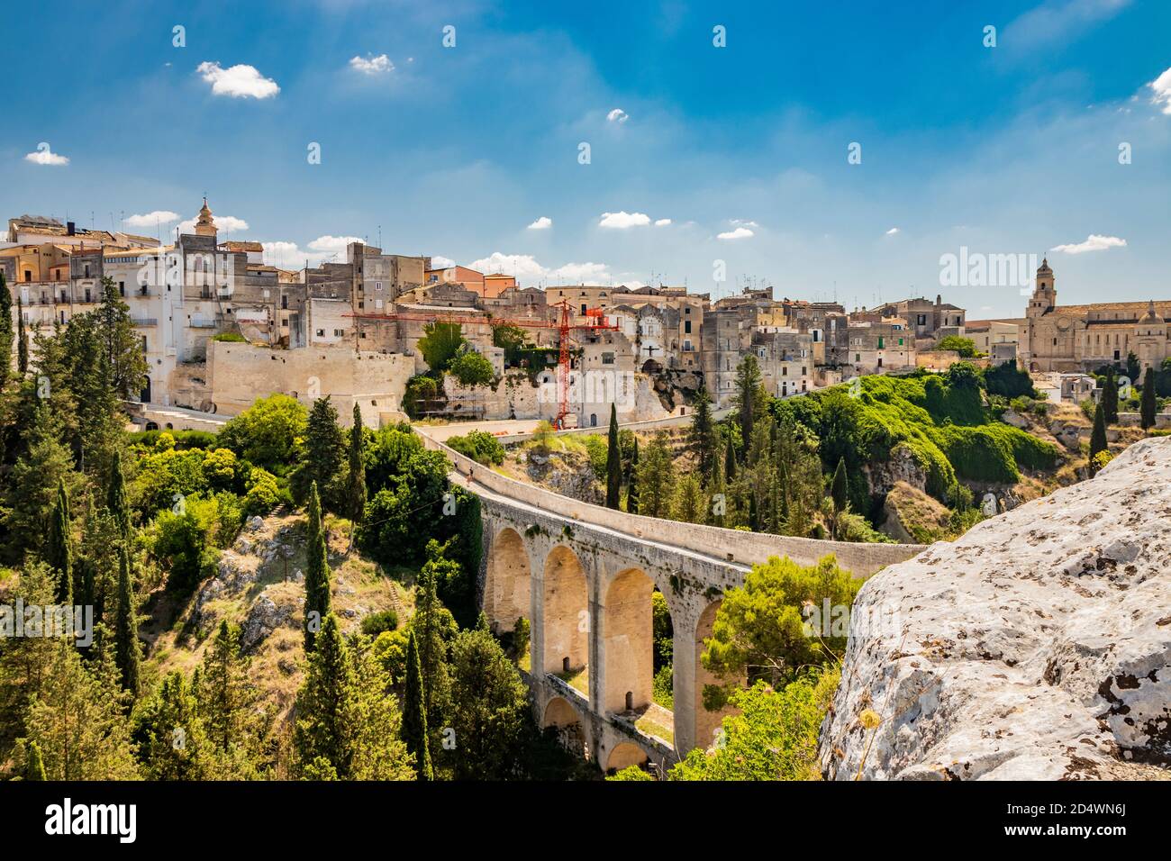 Gravina in Puglia, Italy. The stone bridge, ancient aqueduct and viaduct. Across the valley the skyline of the city with its houses and buildings and Stock Photo