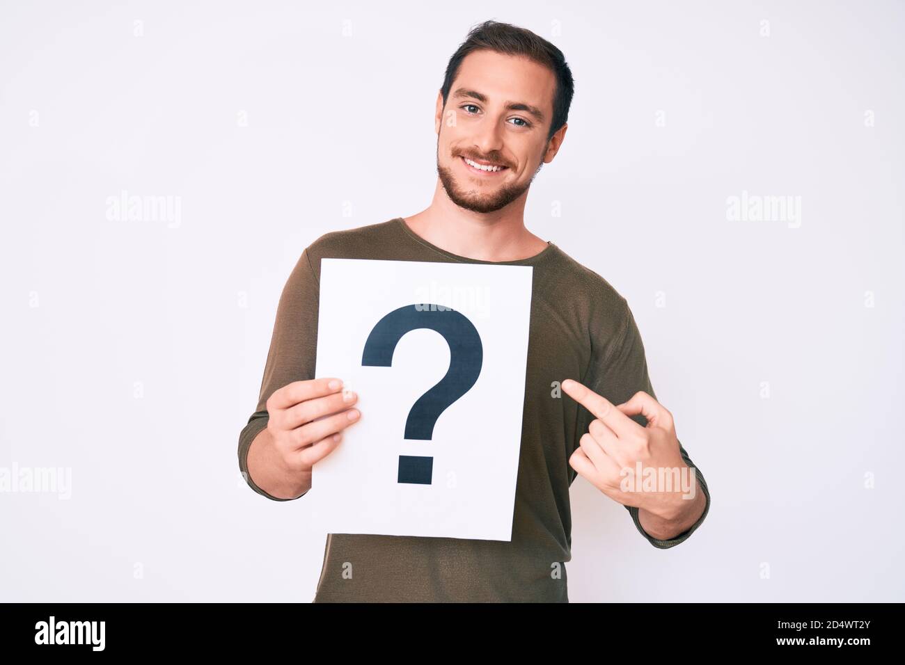 Young handsome man holding question mark smiling happy pointing with ...