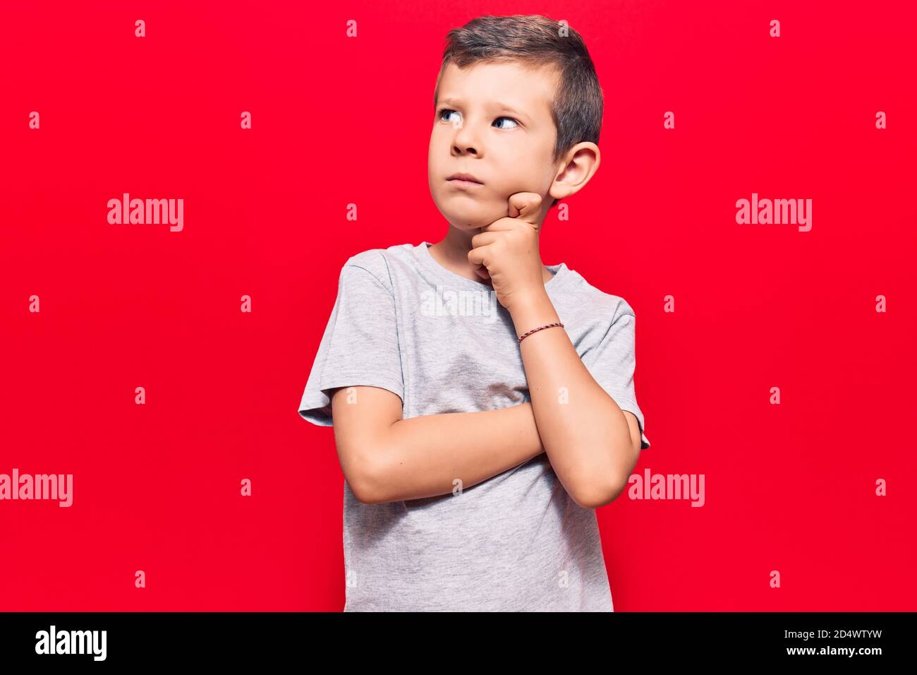 Cute blond kid wearing casual clothes serious face thinking about ...
