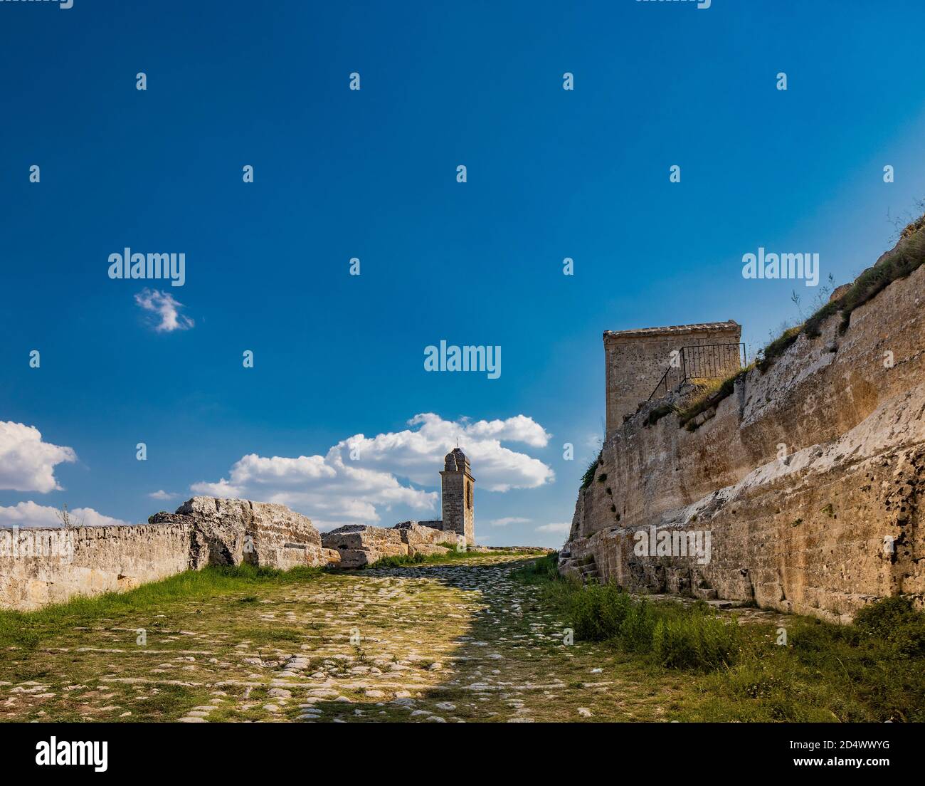 Gravina in Puglia, Italy. The path of pebbles and stones that leads to the Sanctuary of Madonna della Stella, with its bell tower and the ancient cave Stock Photo