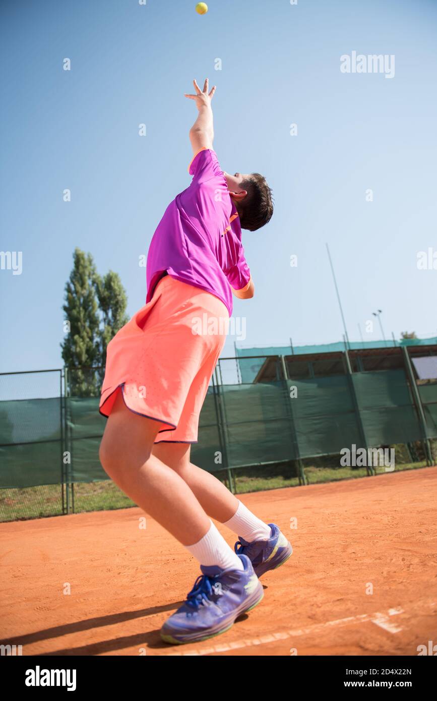 Young tennis player serving the ball Stock Photo
