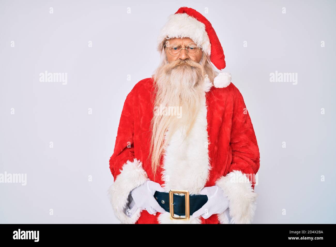Old senior man with grey hair and long beard wearing santa claus costume with suspenders skeptic and nervous, frowning upset because of problem. negat Stock Photo