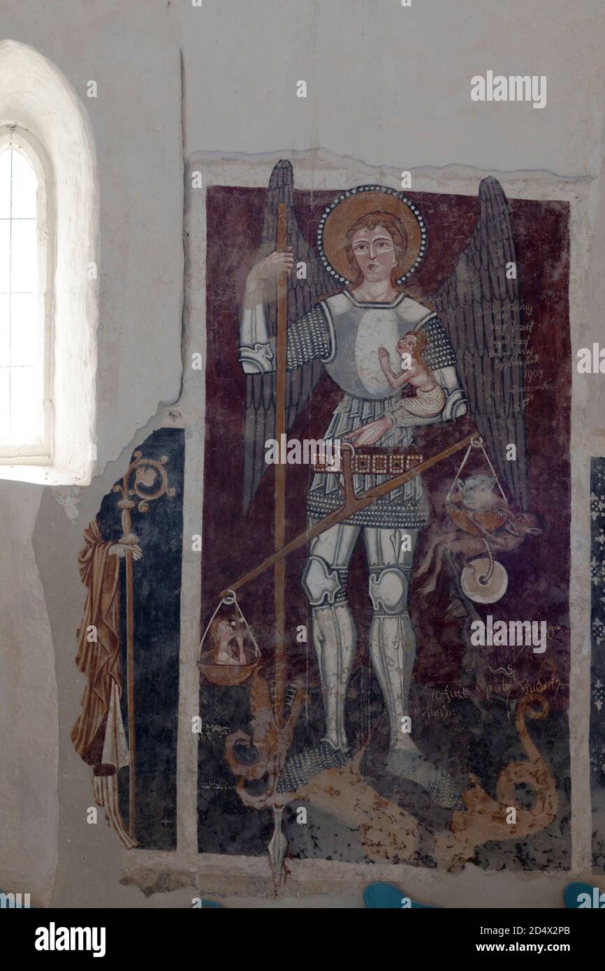 St Michael, who weighs souls. He kills the dragon with his spear. Fresco detail in the UNESCO World Heritage Listed Unitarian Fortified Church. Stock Photo