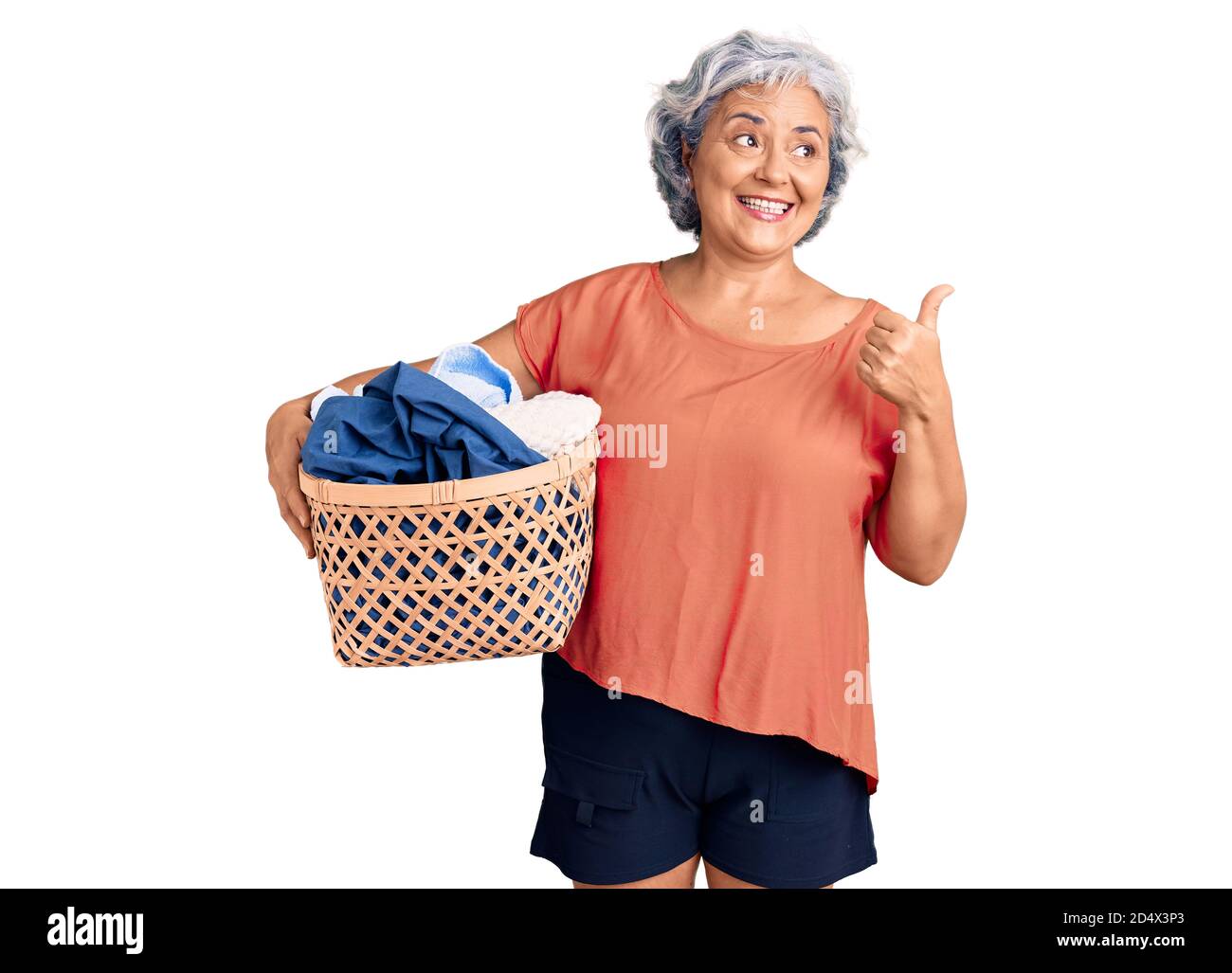 https://c8.alamy.com/comp/2D4X3P3/senior-woman-with-gray-hair-holding-laundry-basket-pointing-thumb-up-to-the-side-smiling-happy-with-open-mouth-2D4X3P3.jpg