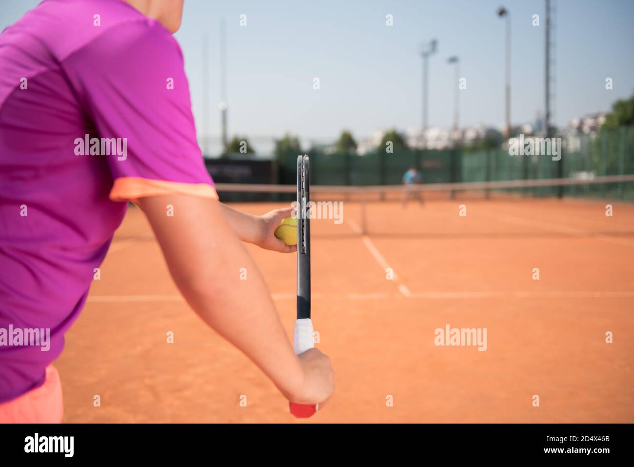 Young tennis player prepares for serving the ball Stock Photo