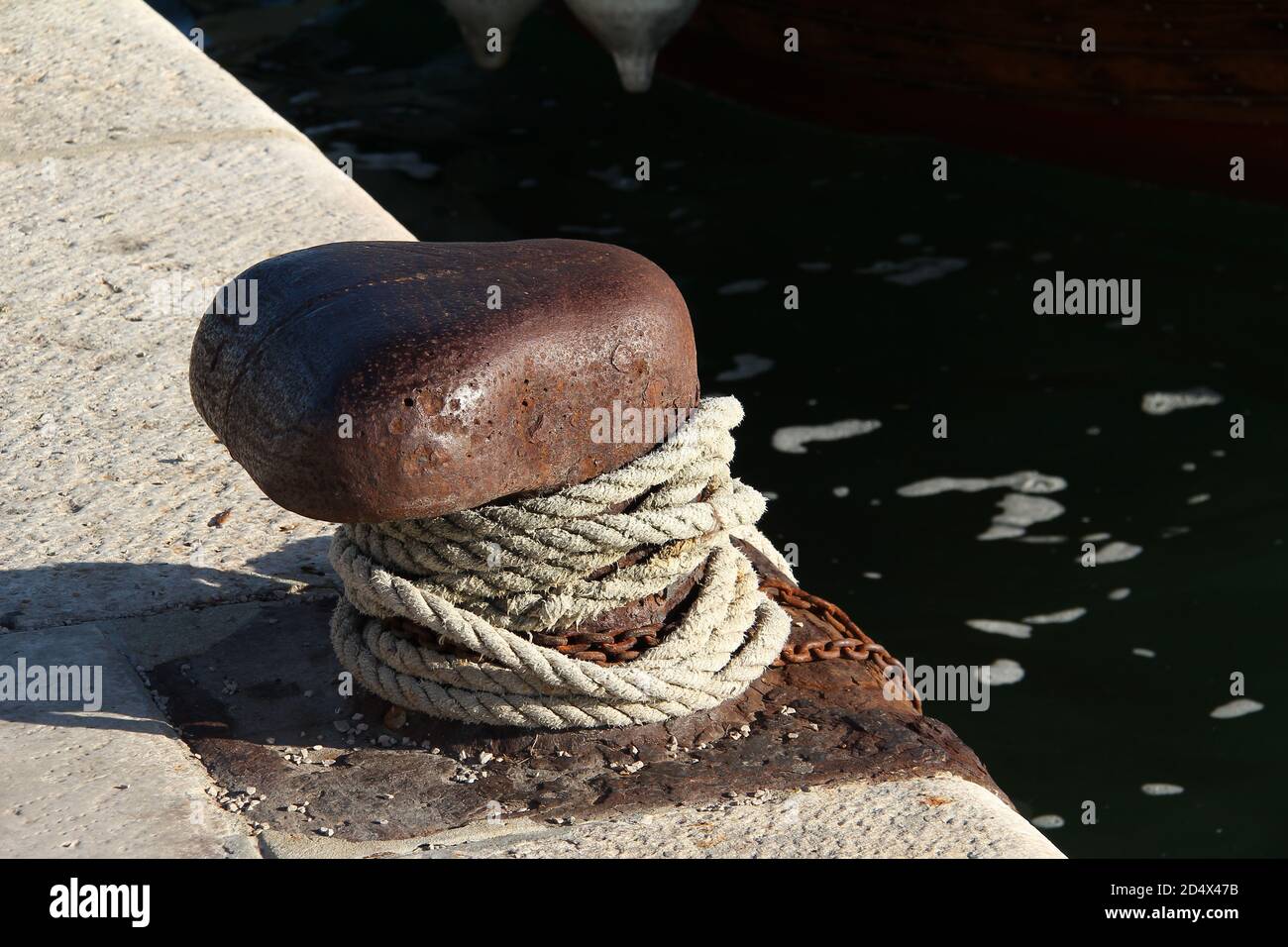 High angle closeup shot of ropes attached to the harbor near the sea ...