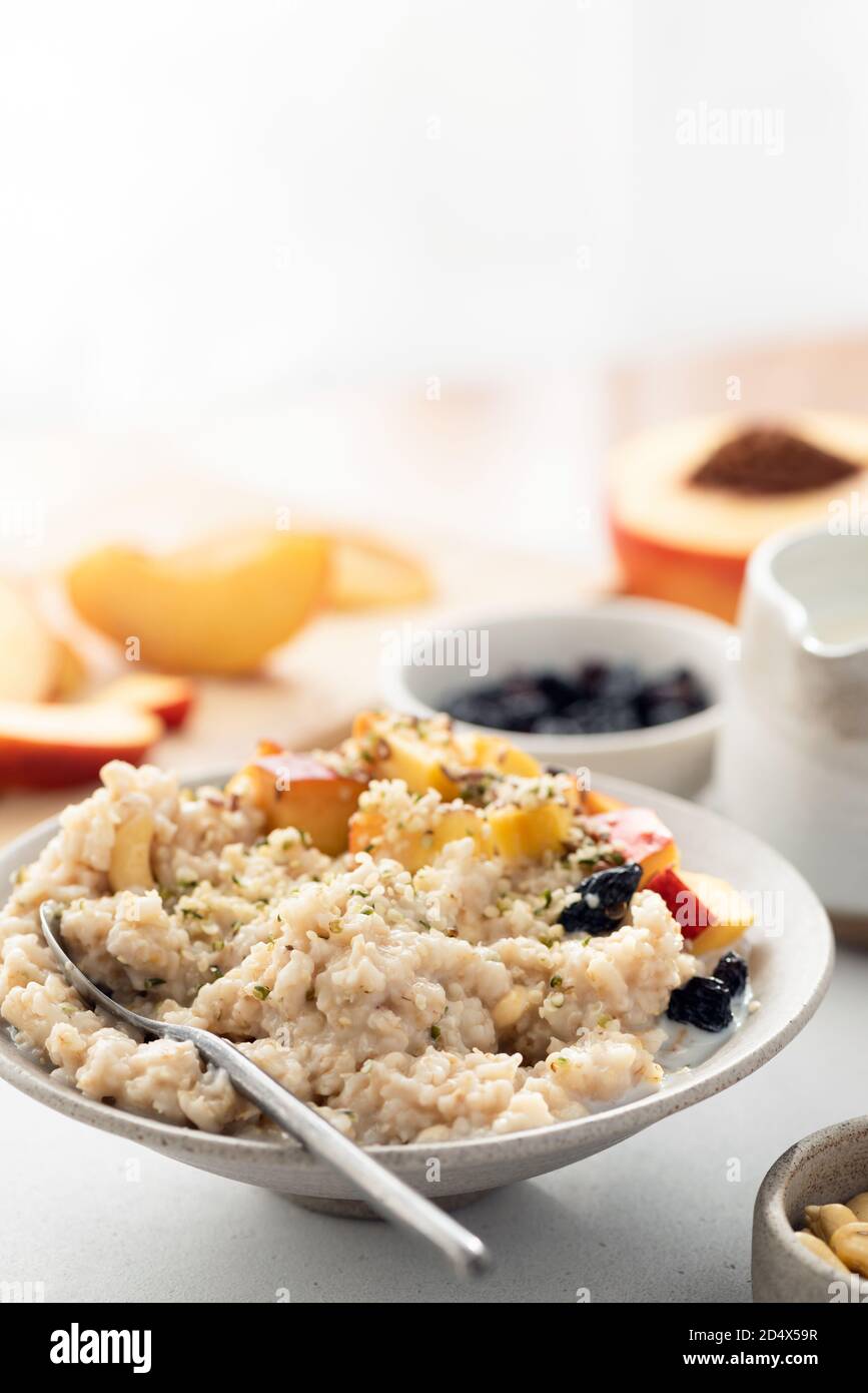 Healthy oatmeal porridge with fruits and hemp seeds for breakfast