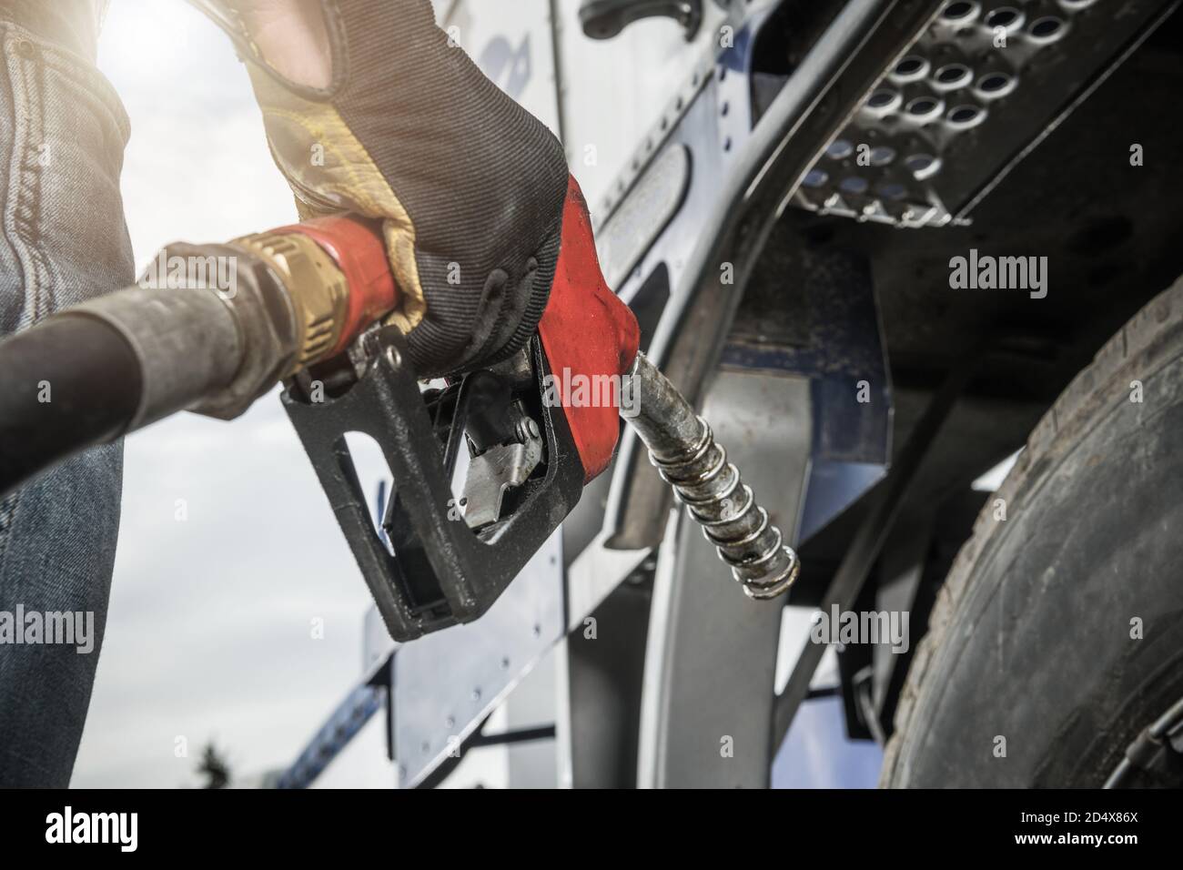 Truck Driver Wearing Safety Gloves Holding Fuel Pump Nozzle in His Hand