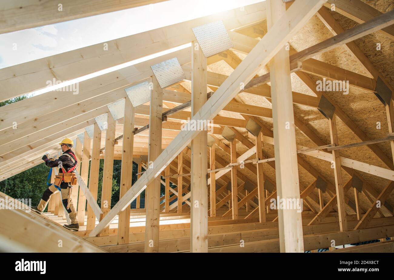 Construction Contractor Worker Building Wooden Roof Skeleton Frame of the Building. Industrial Theme. Stock Photo