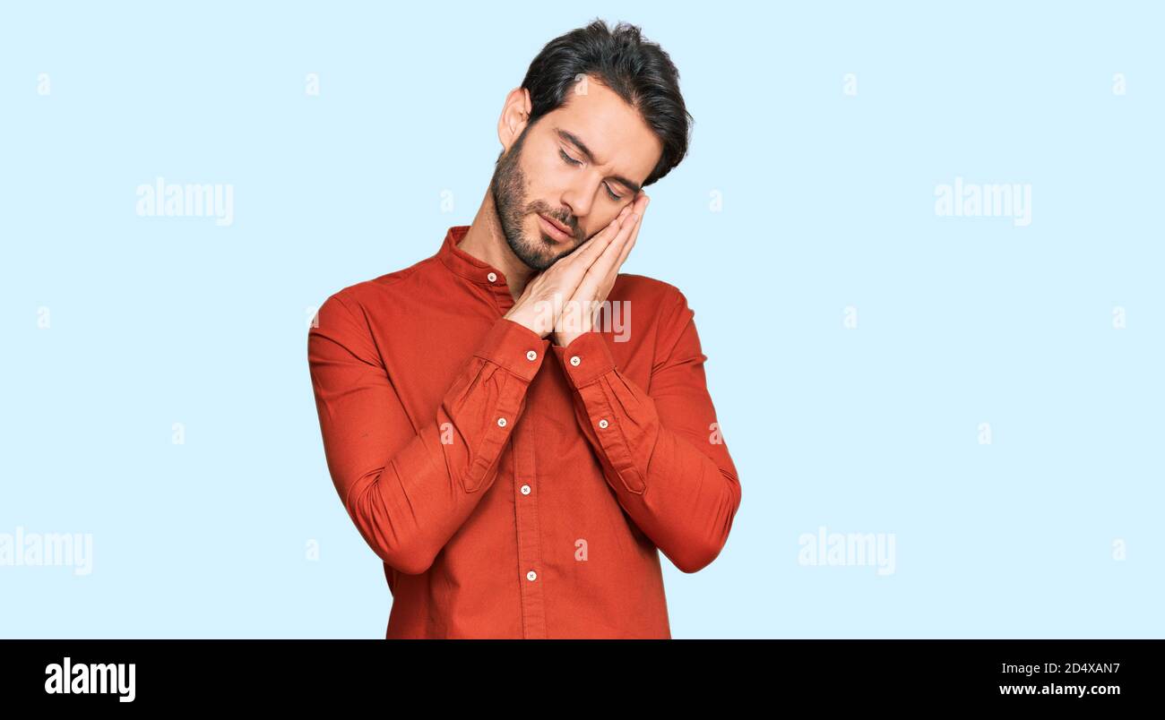 Young hispanic man wearing casual clothes sleeping tired dreaming and ...