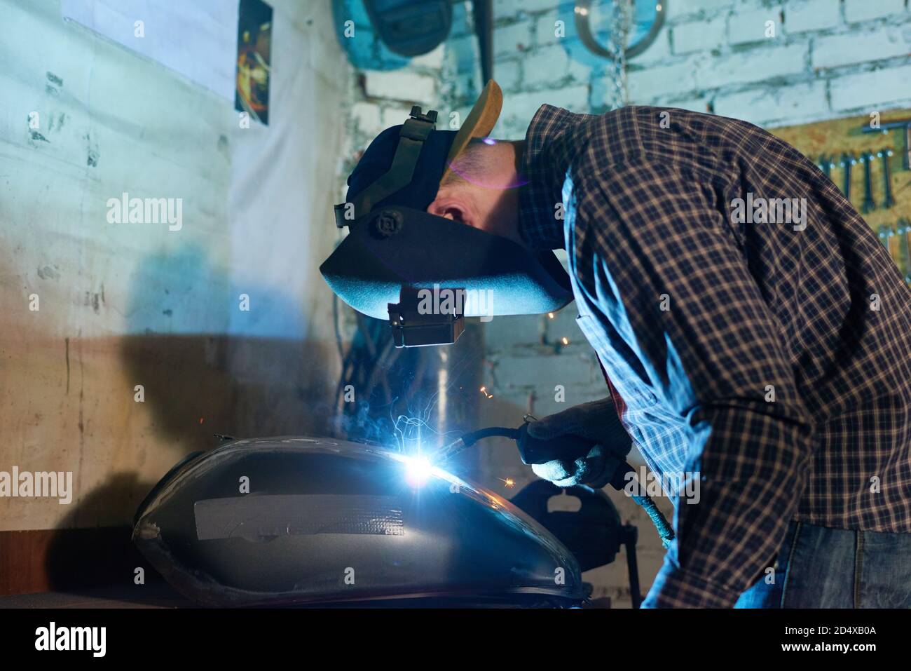 Professional repairman welding motorbike fuel tank part Stock Photo Alamy