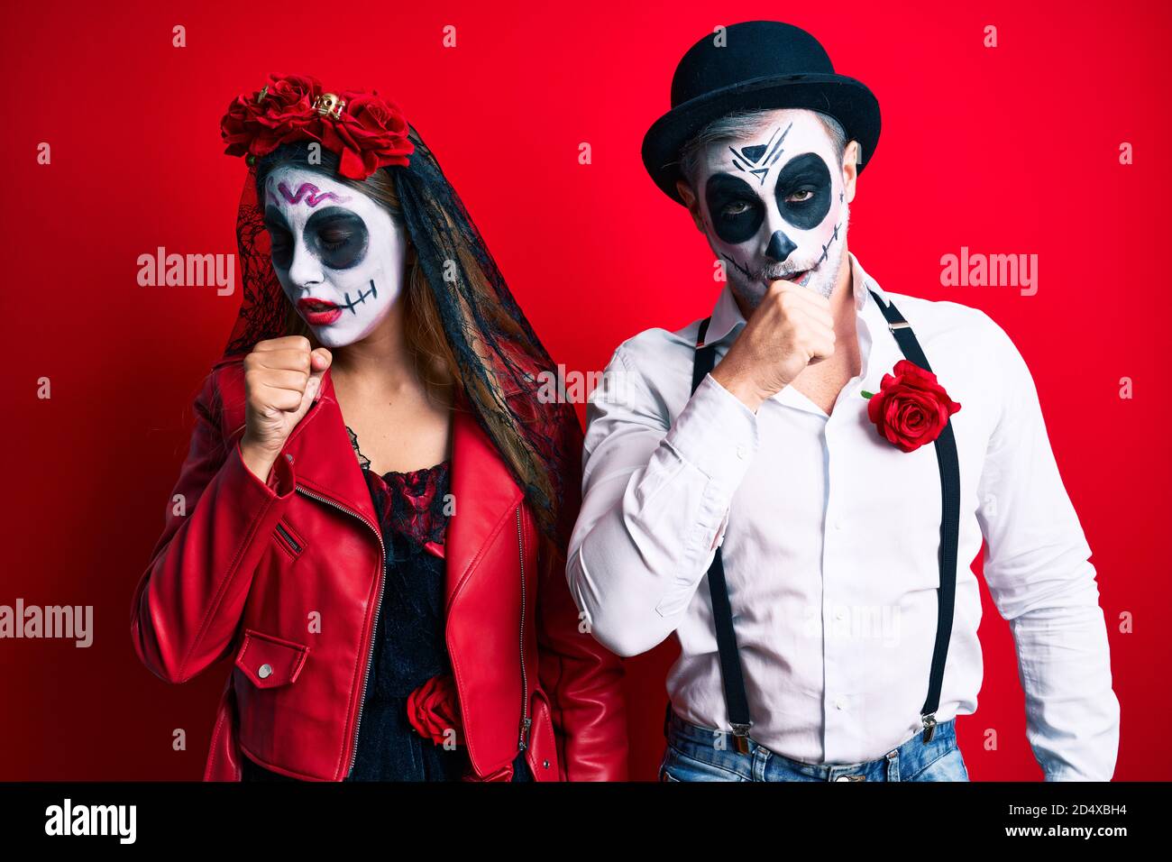 Couple wearing day of the dead costume over red feeling unwell and