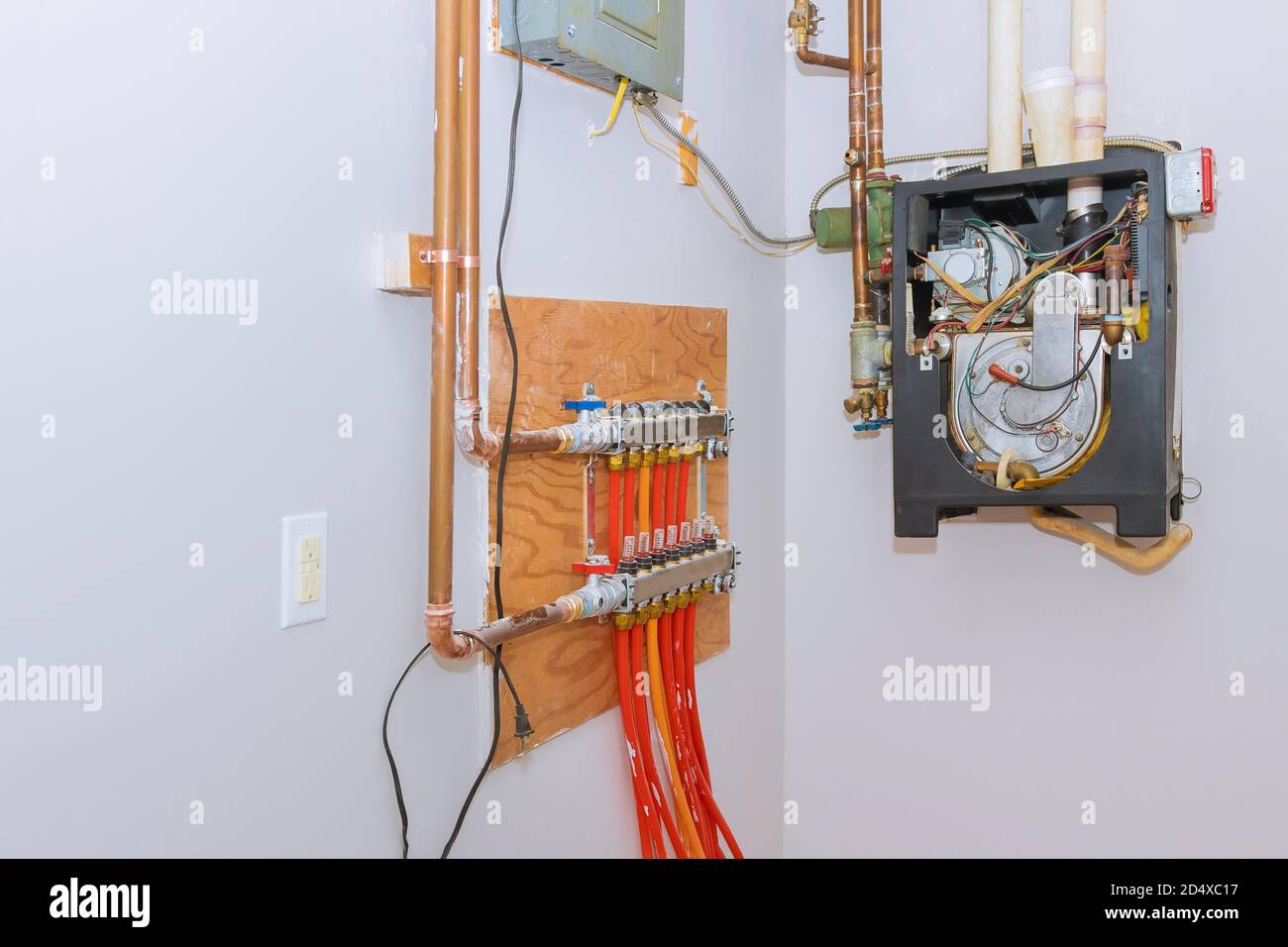 Pipelines in main control manifold of house distributor of central heating with red valves Stock