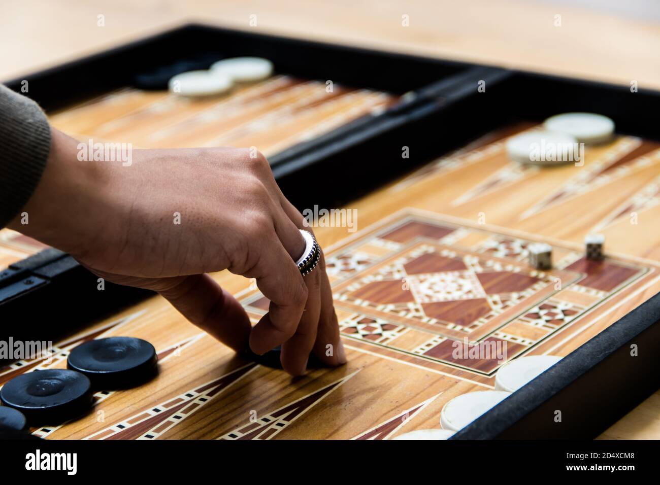Woman hand moving the checkers in a backgammon game Stock Photo