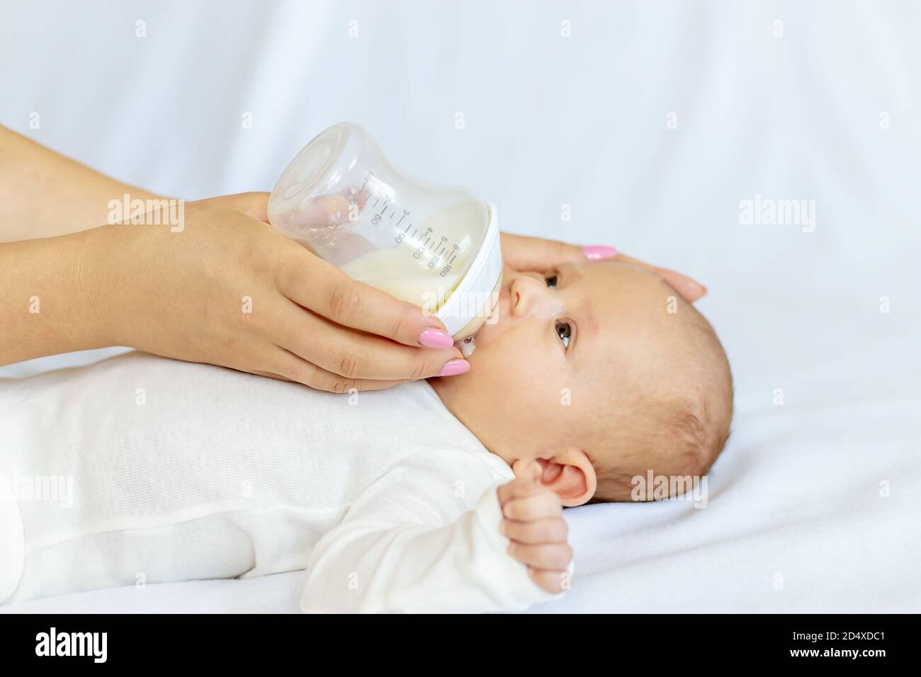 Mother feeds her newborn baby from a bottle. Selective focus. Food