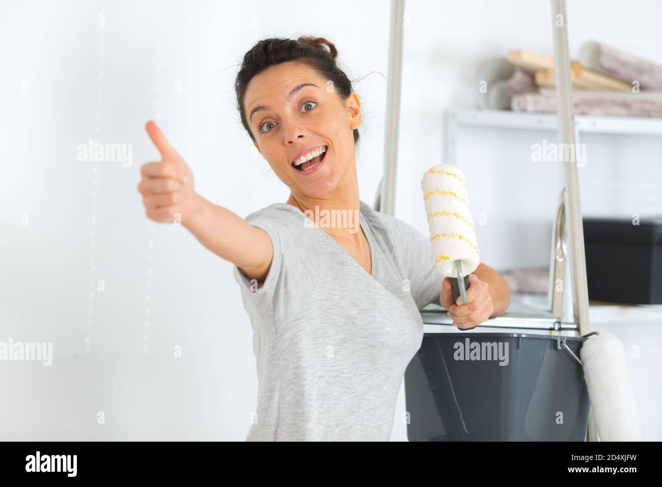 happy beautiful young woman doing wall painting Stock Photo - Alamy