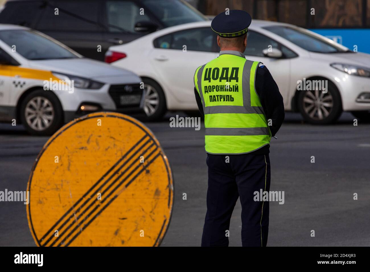 Moscow, Russia. 3rd of October, 2020 An employee of Moscow's Traffic Management Center regulates traffic at the intersection of Tverskaya street in the center of Moscow, Russia. The inscription on man's back reads 'Traffic management center, road patrol' Stock Photo