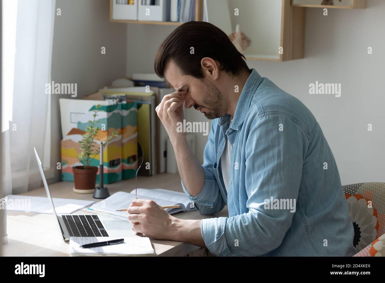 Tired young man dropped off eyeglasses, suffering from painful feelings