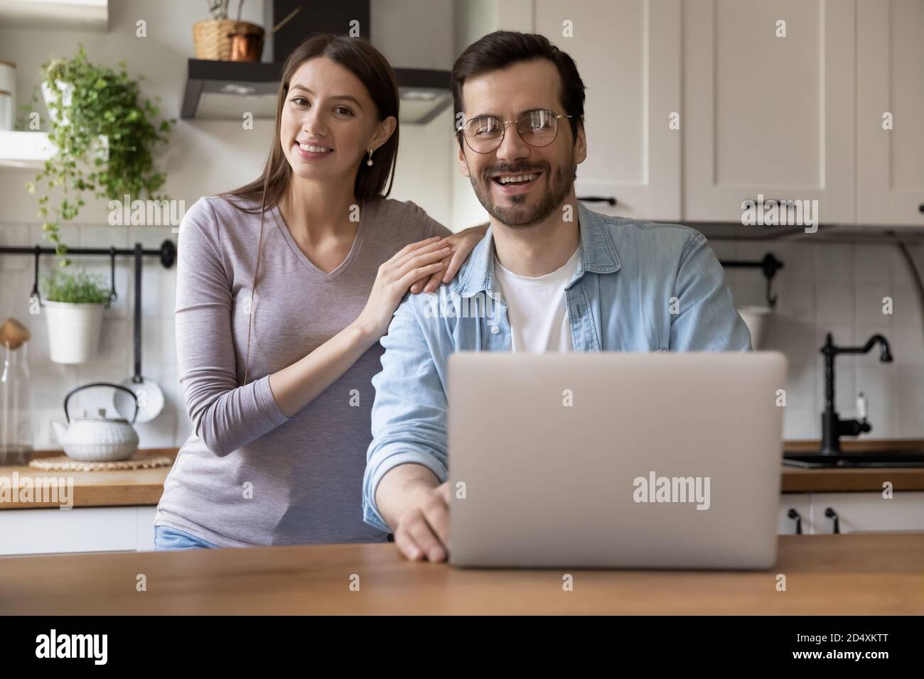 Happy millennial married family couple using computer. Stock Photo