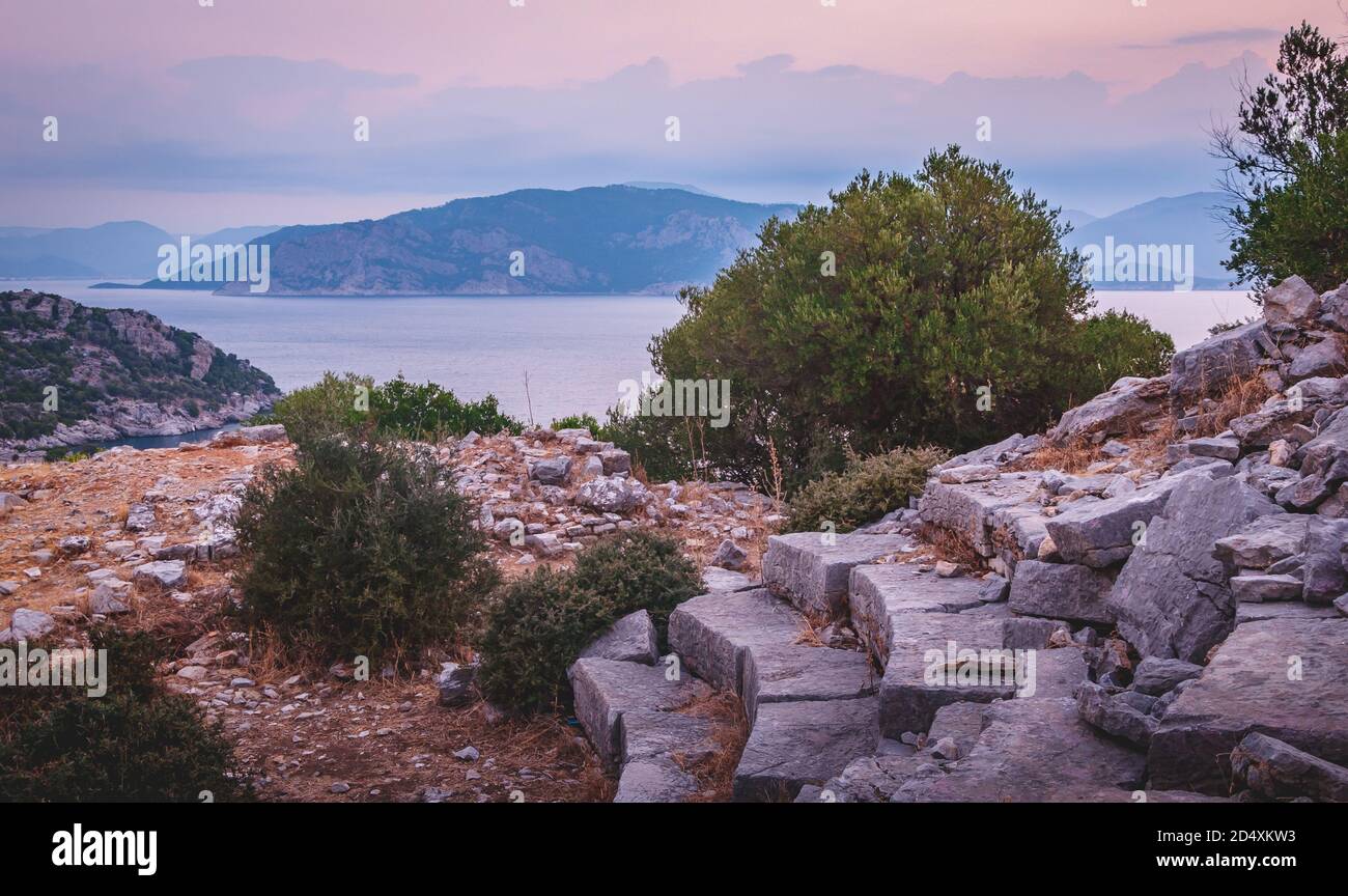 The amphitheatre at the ancient ruins of Amos, near Marmaris, Mugla, Turkey at dawn with view of Yildiz Island in background Stock Photo