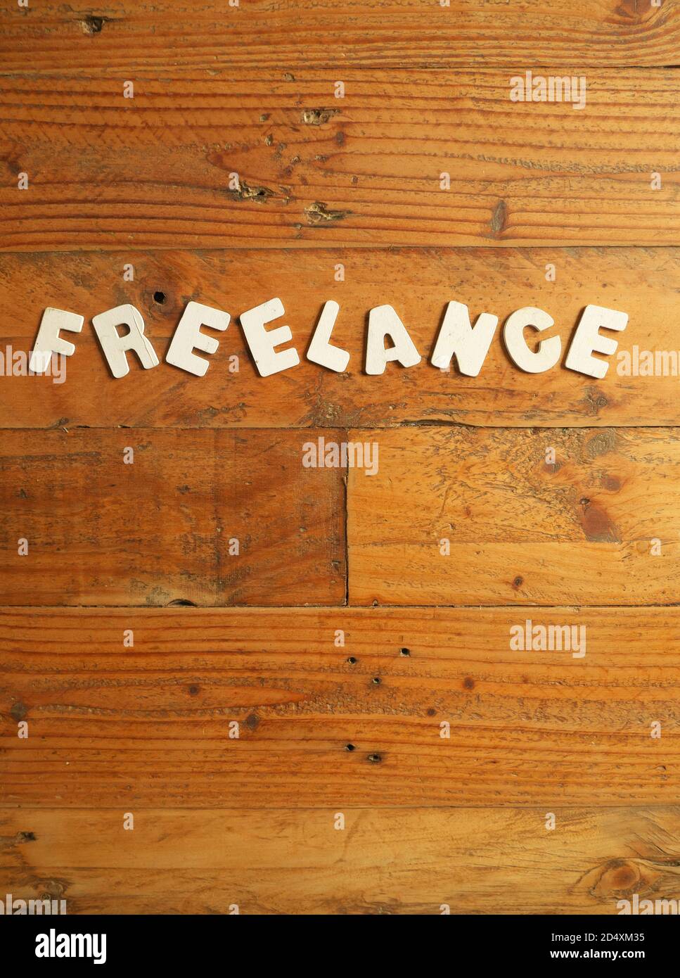 Word « FREELANCE » in white letters on a wooden background Stock Photo