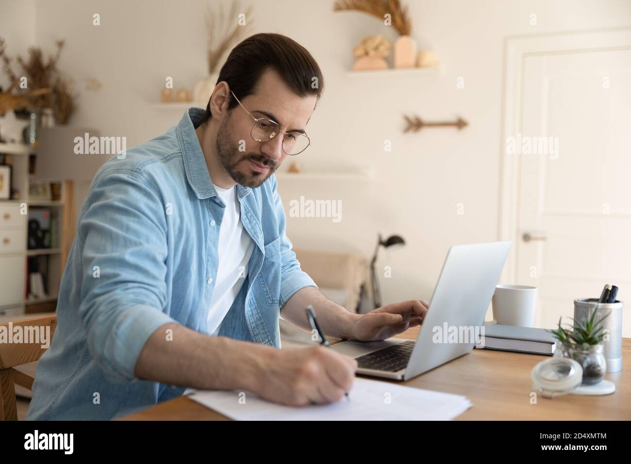 Focused young man watching educational webinar lecture on computer. Stock Photo