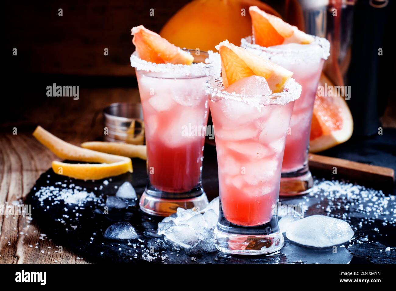 Cocktail salty dog with grapefruit juice, vodka, salt and ice, black background, selective focus