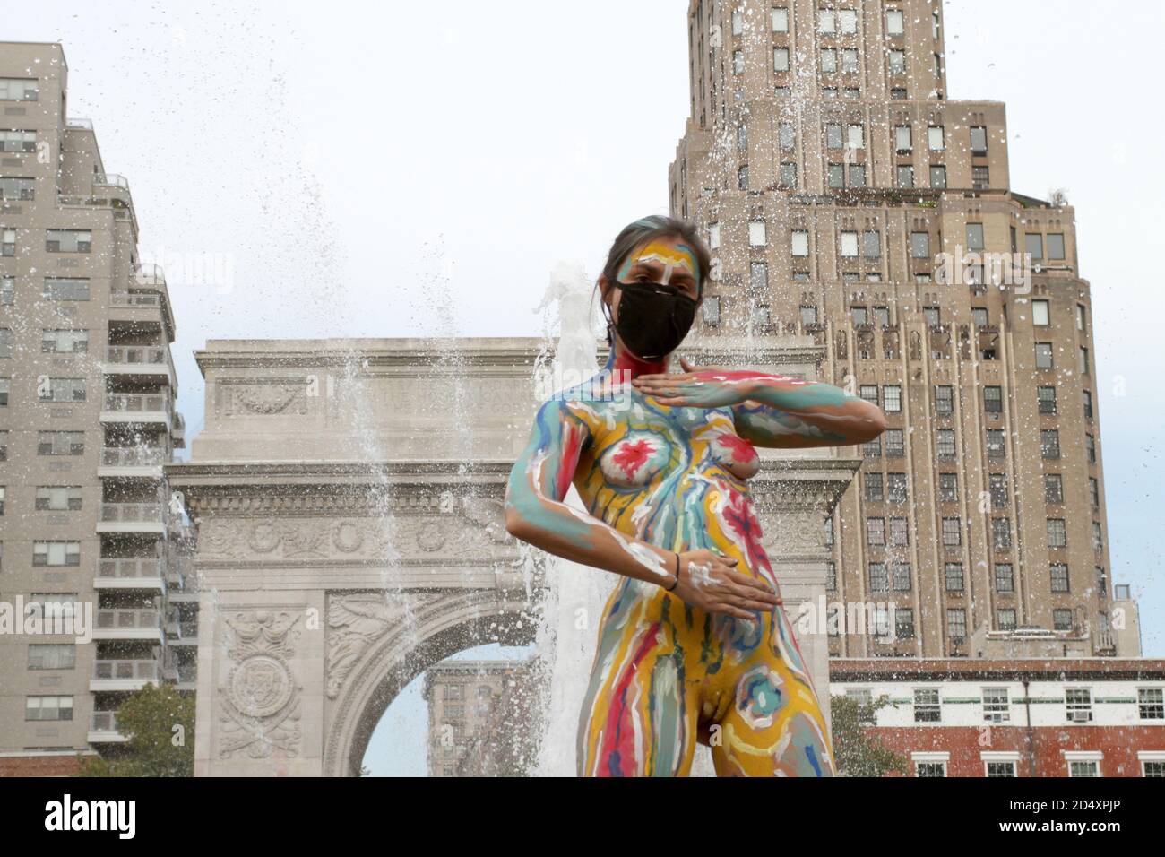 October 10, 2020, New York, New York, USA: Andy Golub founder and Executive Director of Human Connection Arts paints two models near the Washington Square Arch in New York's Greenwich Village neighborhood. (Credit Image: © Bruce Cotler/ZUMA Wire) Stock Photo