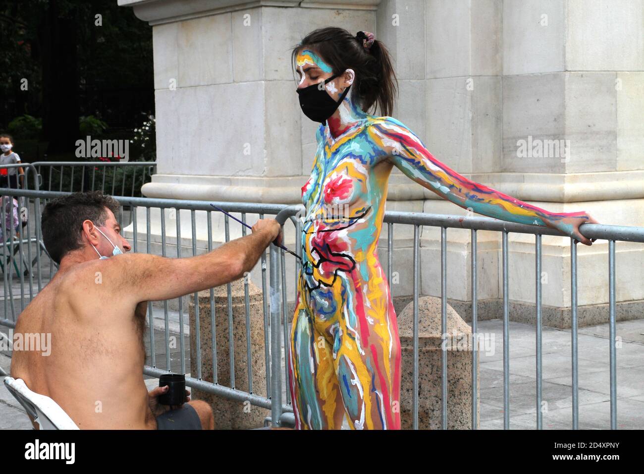 October 10, 2020, New York, New York, USA: Andy Golub founder and Executive Director of Human Connection Arts paints two models near the Washington Square Arch in New York's Greenwich Village neighborhood. (Credit Image: © Bruce Cotler/ZUMA Wire) Stock Photo