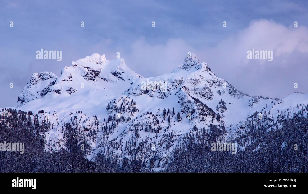 View to the snowy Sky Pilot mountain covered in clouds, Squamish, British Columbia, Canada Stock Photo