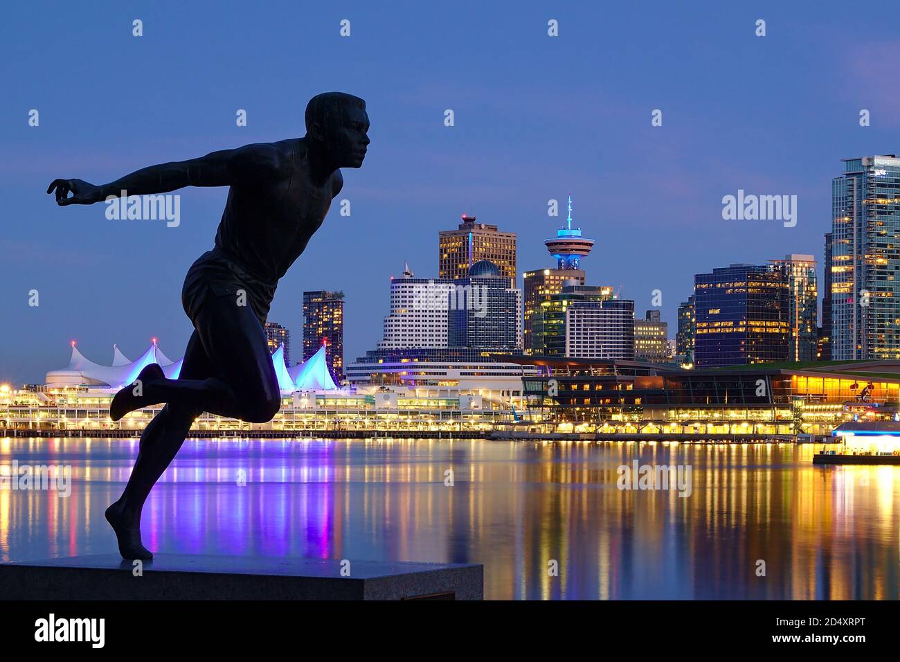 Vancouver, British Columbia - May 14, 2020 - Sprinter statue (Harry Jerome) in Stanley Park with Vancouver Downtown night skyline in the background, b Stock Photo