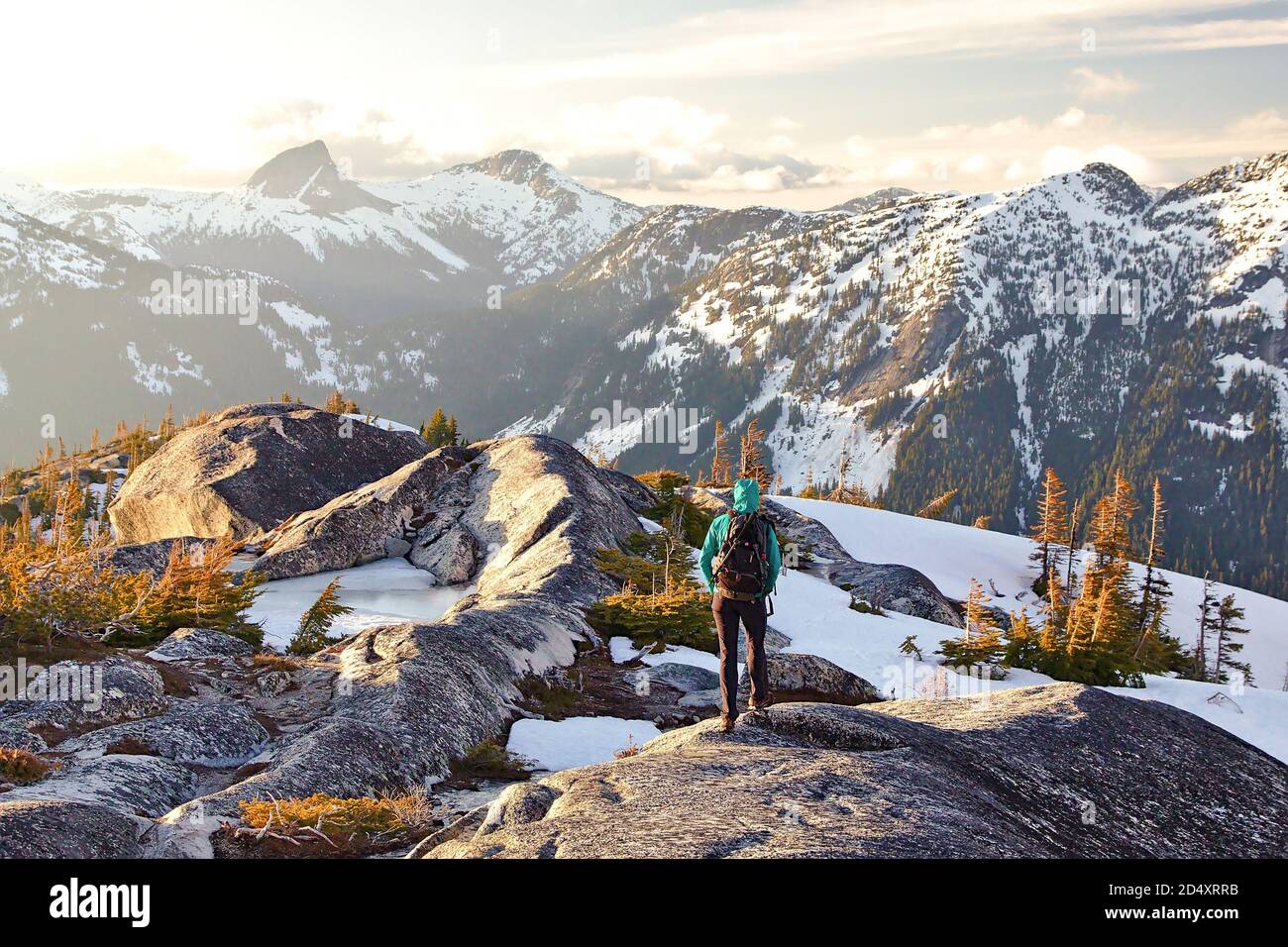 Young woman hiker in mountains during sunset a with view of snow covered peaks, Needle Peak, Coquihalla, British Columbia, Canada Stock Photo