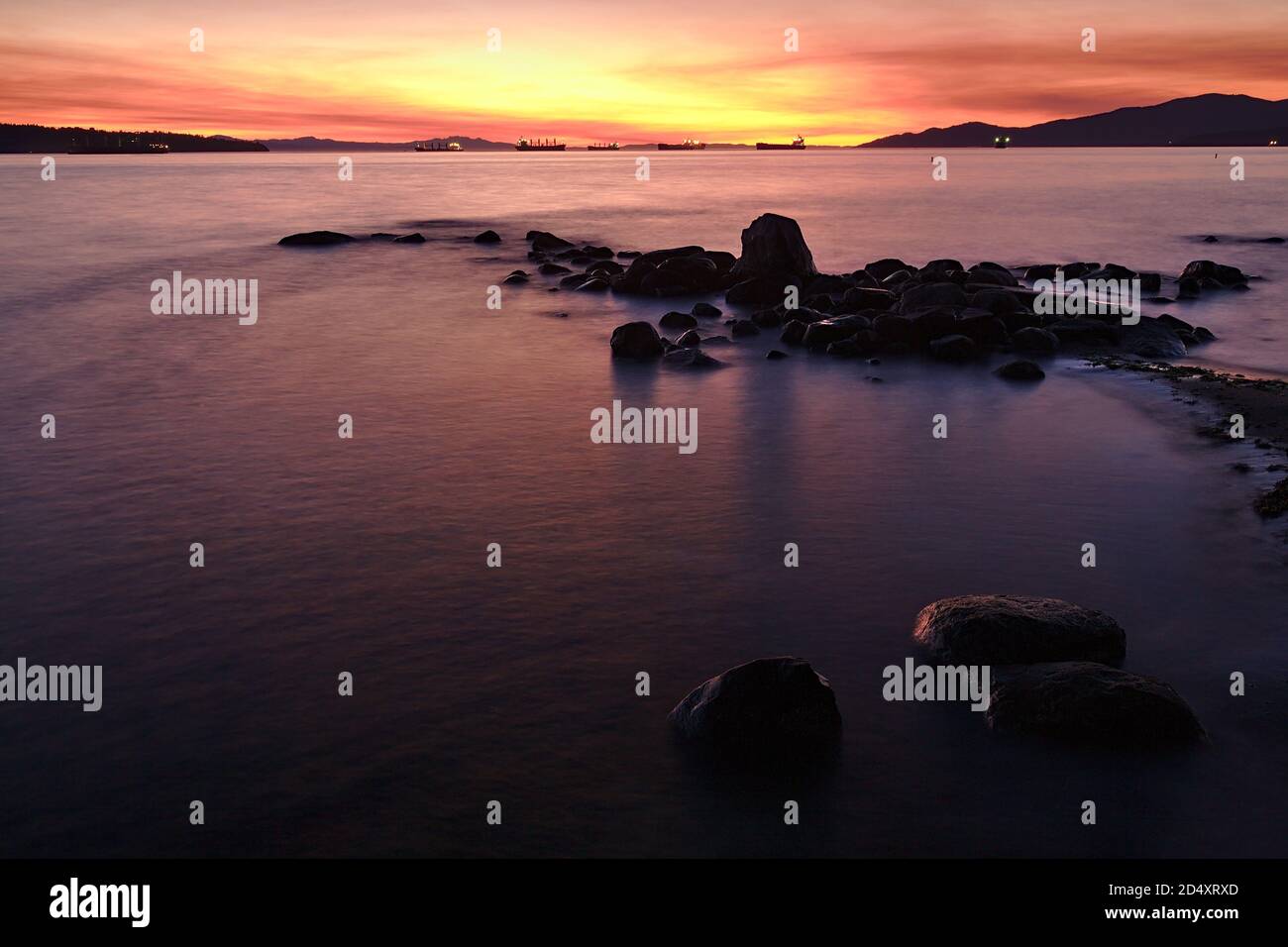 Long exposure of ocean beach with rocks. Twilight scene during a sunset from Stanley Park, Vancouver, British Columbia, Canada Stock Photo