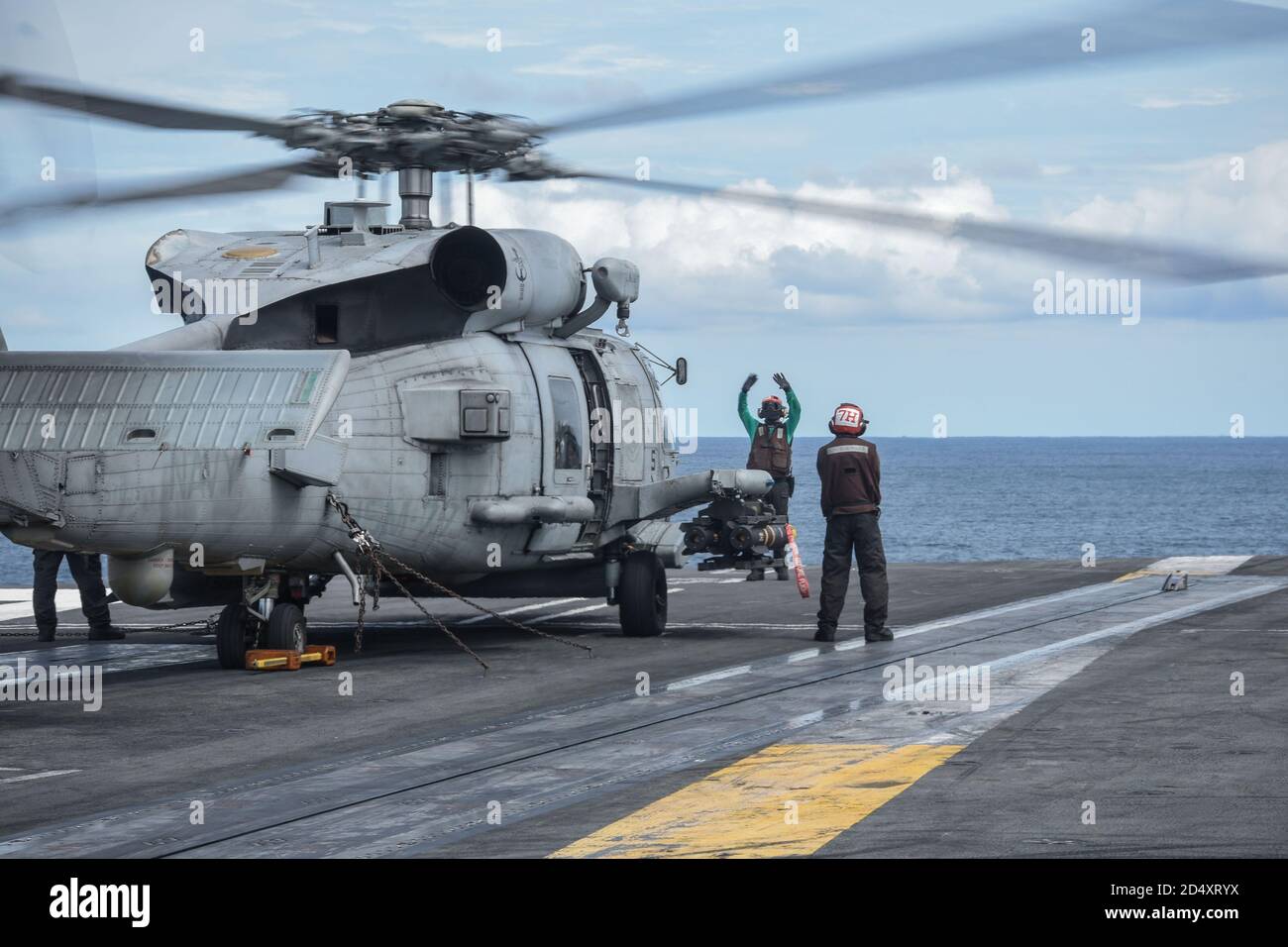 201011-N-ZF088-1093 INDIAN OCEAN (Oct. 11, 2020) Sailors assigned to the Saberhawks of Helicopter Maritime Strike Squadron (HSM) 77 signals an MH-60R Sea Hawk on the flight deck of the Navy’s only forward-deployed aircraft carrier USS Ronald Reagan (CVN 76). Ronald Reagan, the flagship of Carrier Strike Group 5, provides a combat-ready force that protects and defends the United States, as well as the collective maritime interests of its allies and partners in the Indo-Pacific. (U.S. Navy photo by Mass Communication Specialist 3rd Class Gabriel A. Martinez) Stock Photo