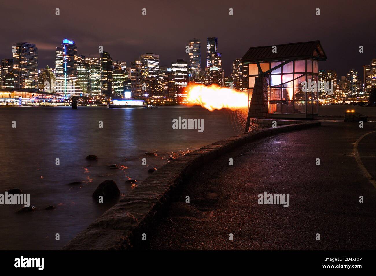 Vancouver 9 O'Clock Gun shooting in dark with cityscape in the background. Stock Photo