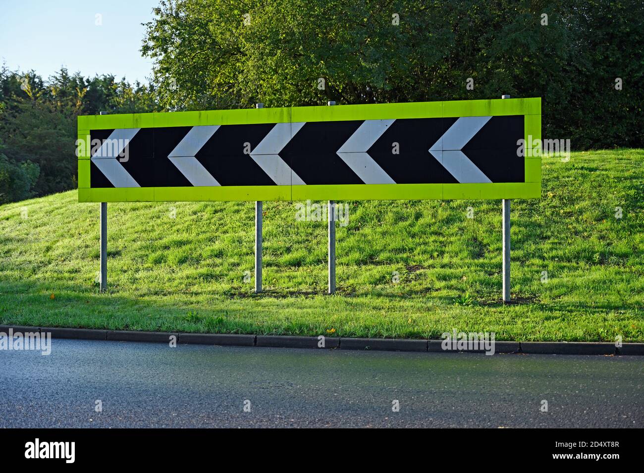 Directional road sign at Wickford, Essex comprising five white chevrons on a black background. Stock Photo