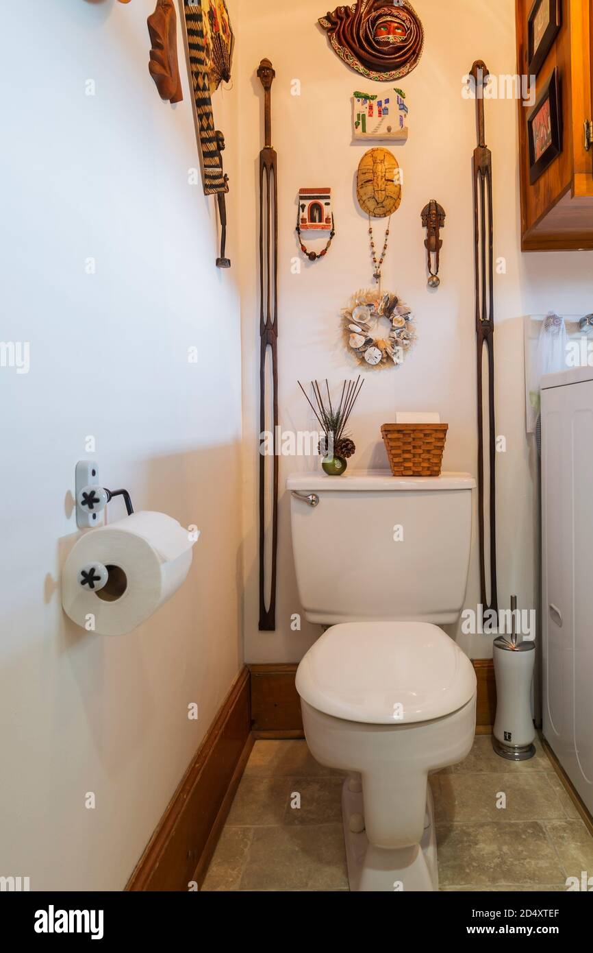 Bathroom with standard toilet and wall decorated with various wood