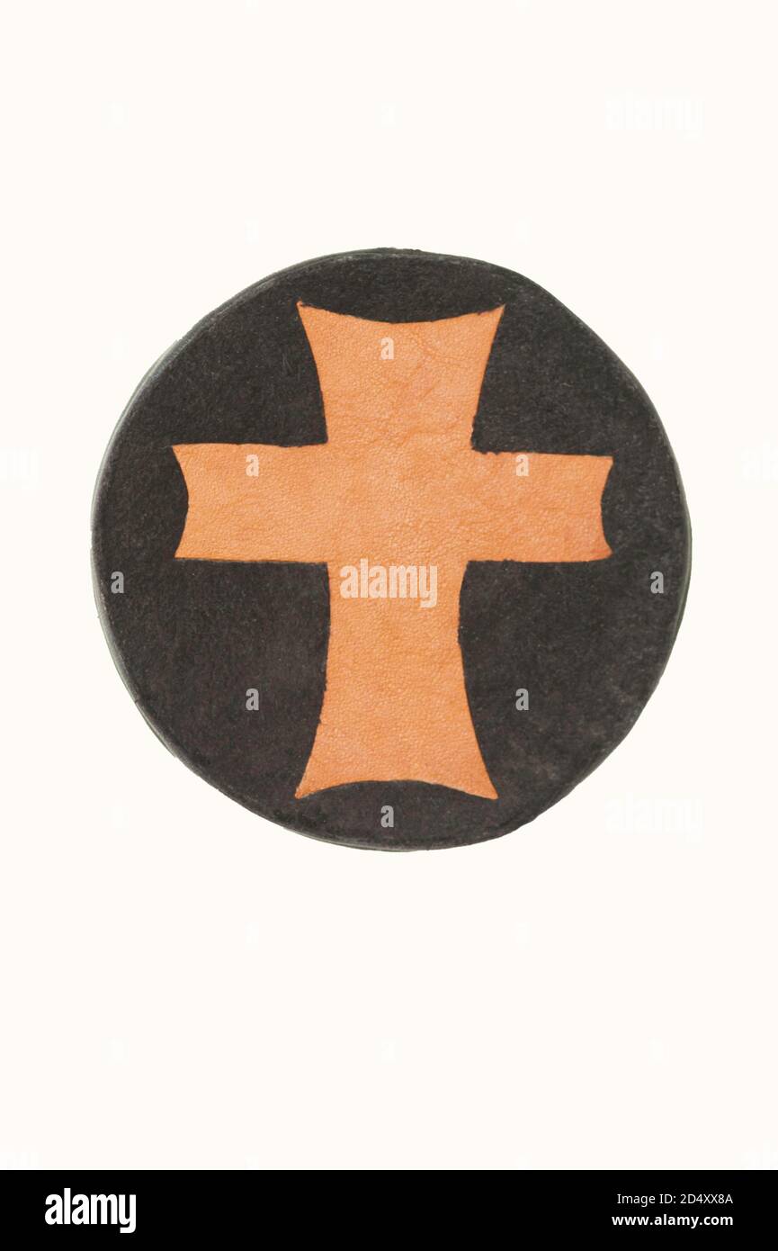 Religious Christian medallion handmade out of 2 leathers depicts the cross of Christ in the world. Stock Photo