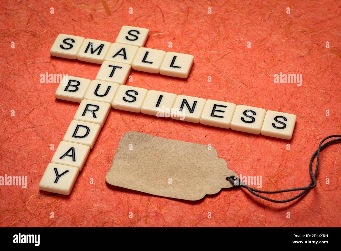 small business Saturday - crossword and blank price tag, holiday shopping concept Stock Photo