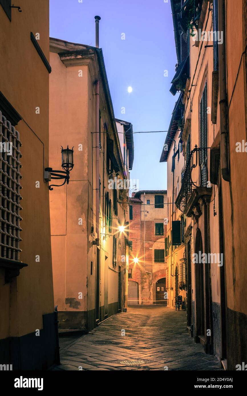 Crescent moon over a narrow residential street in the old part of Lucca, Italy Stock Photo