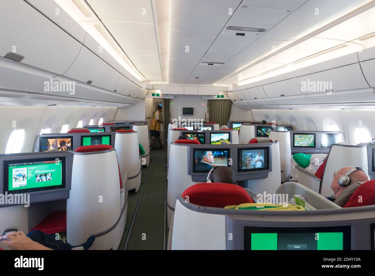 Ethiopian Airlines Airbus A350 Business Class cabin Cloud Nine with full flat bed seats. Travellers relaxing watching PTV. Stock Photo