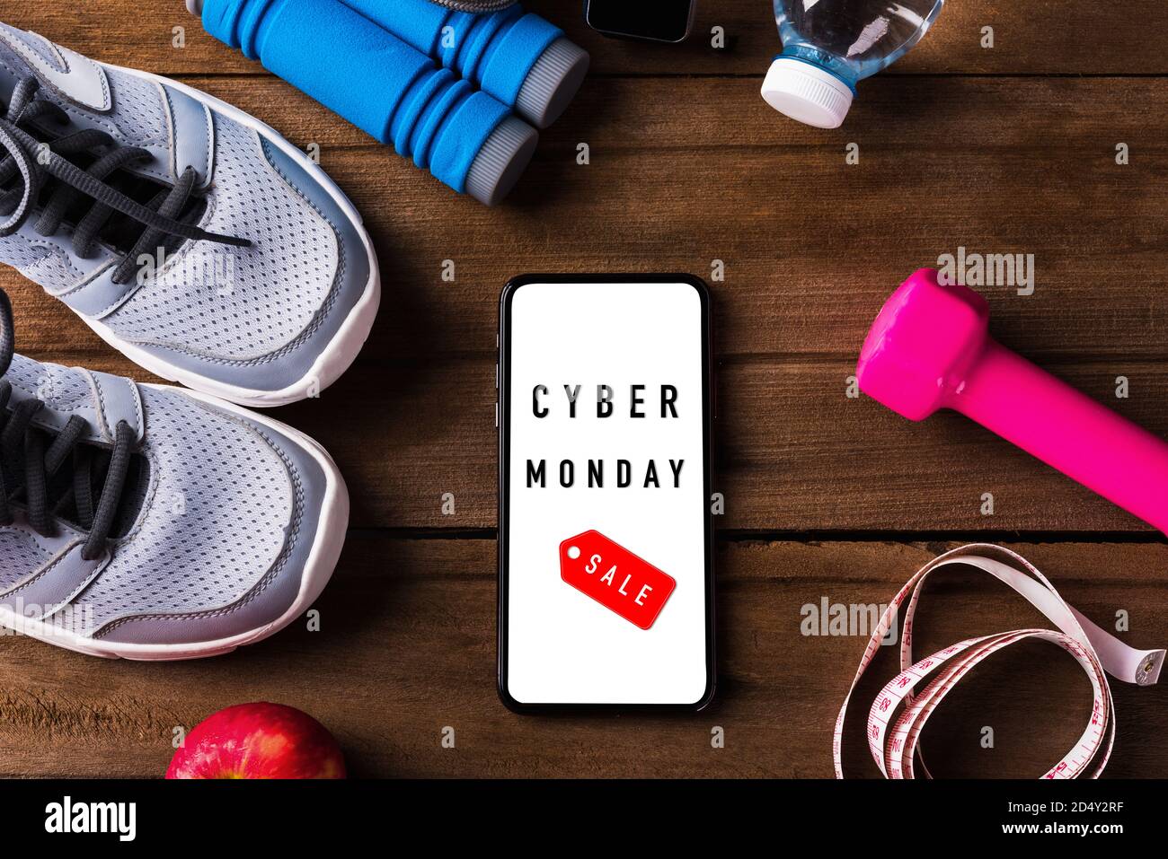 Cyber Monday sale concept with pair sports shoes, water, apple, jump rope and smartphone blank screen on wood table, Gray sneakers and accessories equ Stock Photo