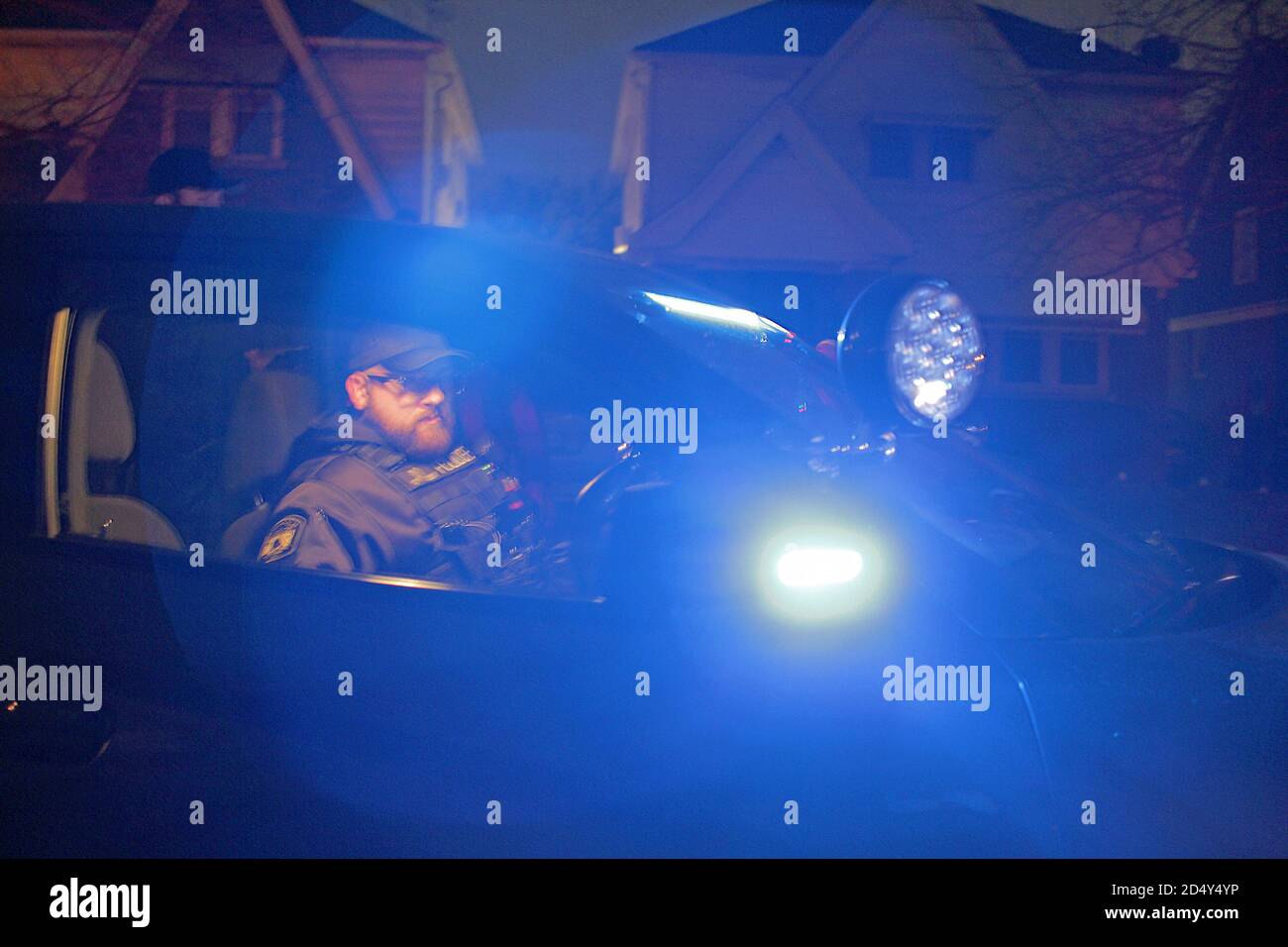 Detroit police officer sitting in his police vehicle at night, Detroit