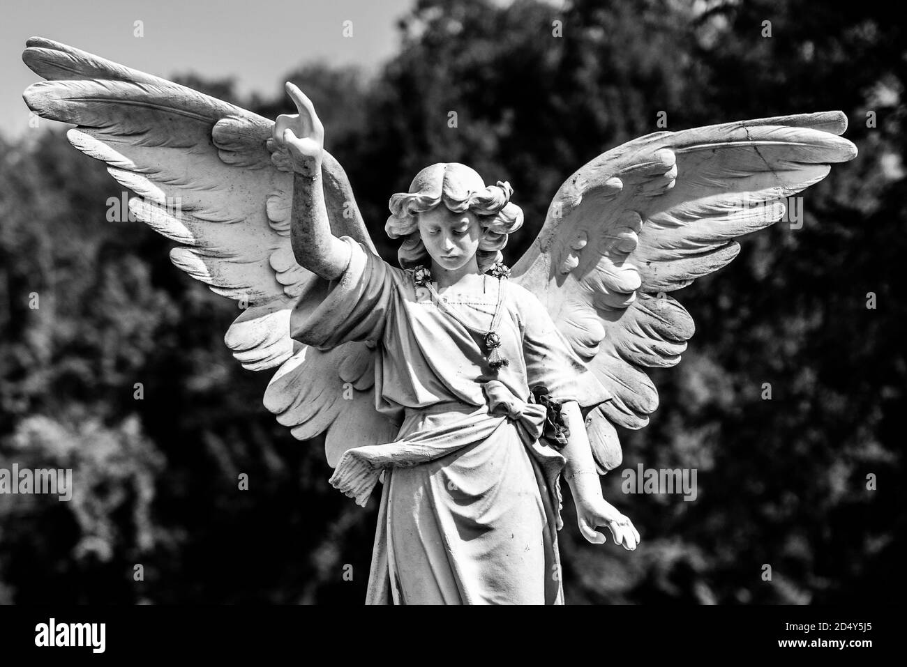 Angel statue standing above a burial mound with wings spread Stock Photo -  Alamy