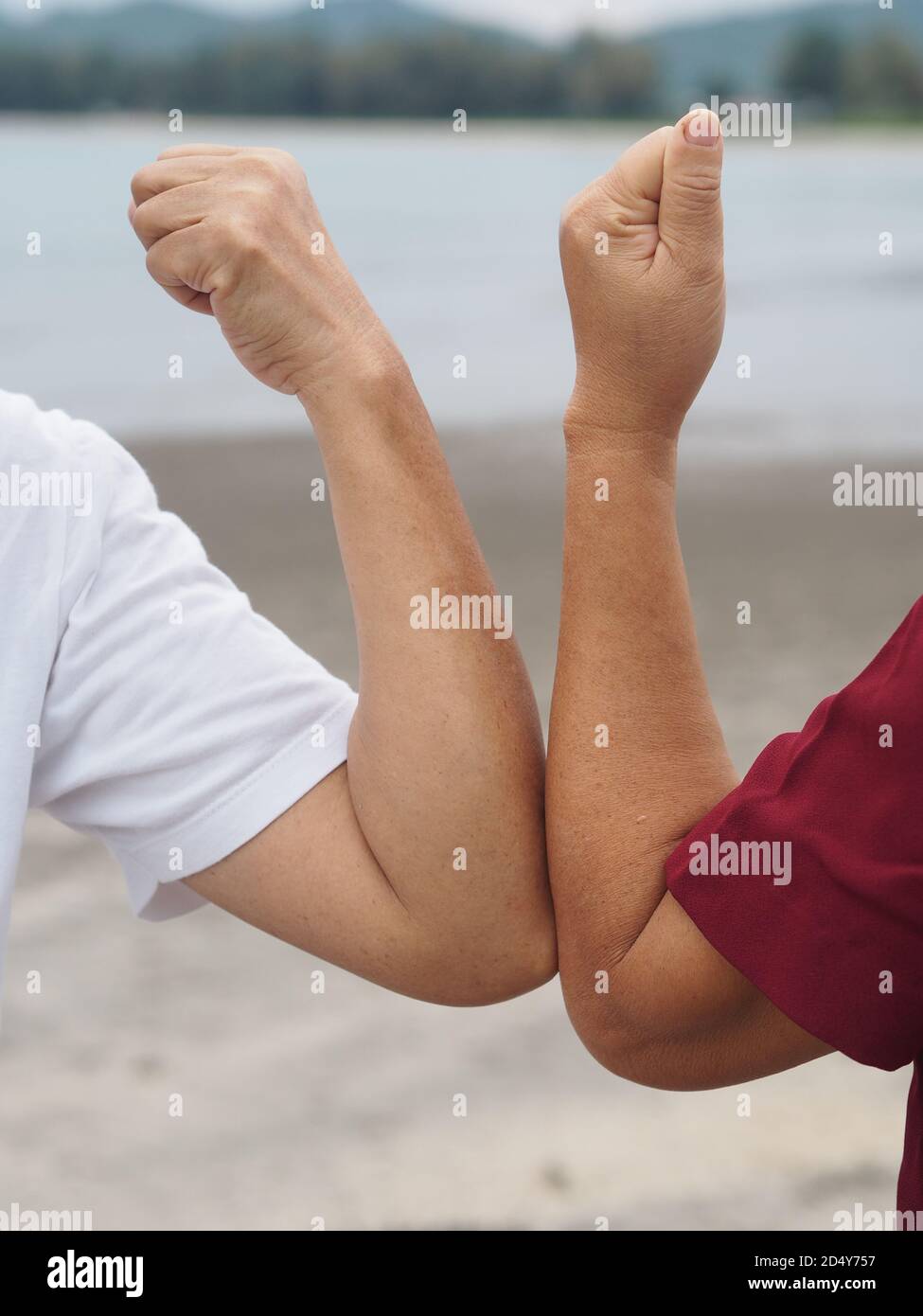 Two woman Alternative handshakes Elbow Bump greeting in the situation of an epidemic covid 19, coronavirus new normal social distancing, Vertical figu Stock Photo