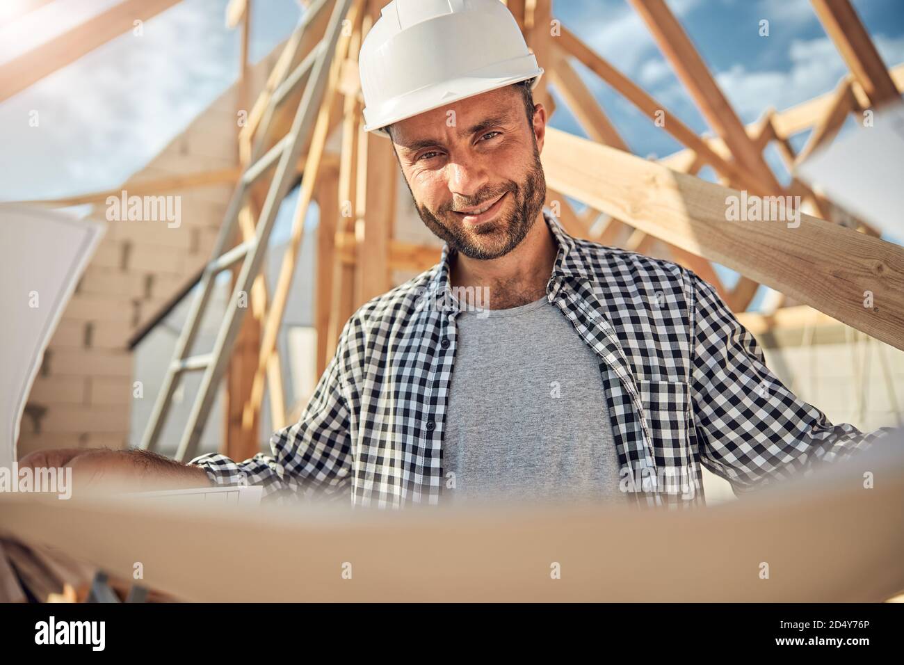 Joyful worker of a construction site holding blueprints Stock Photo - Alamy