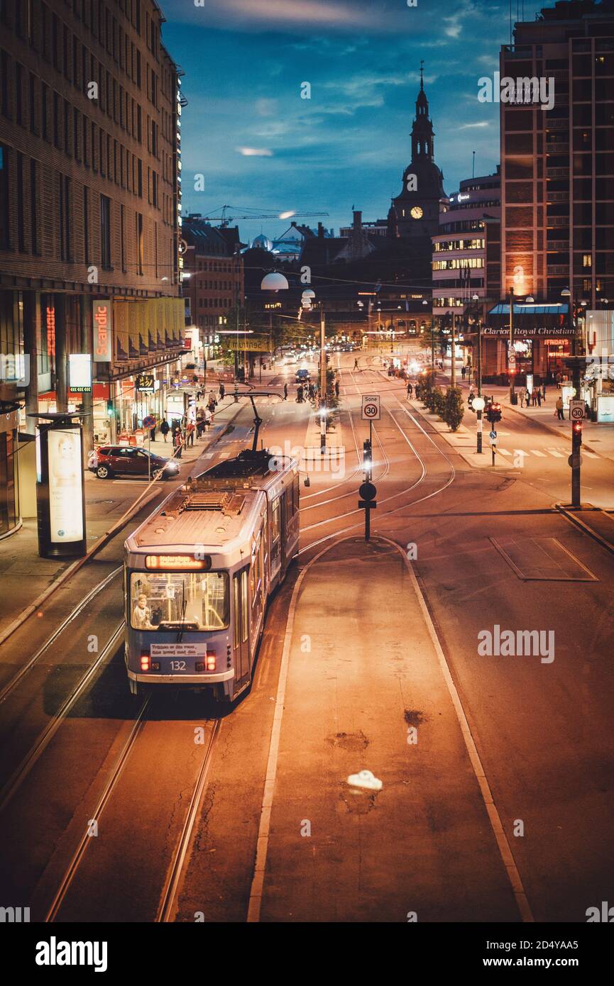 Oslo / Norway - July 23 2015 : Trams running in front of Oslo train station, city night views in the business district from above, crowded shopping ar Stock Photo