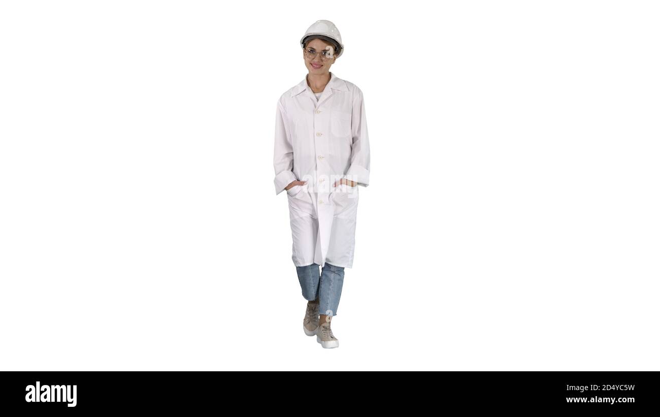 Woman in a white lab coat and hard hat walking on white backgrou Stock ...